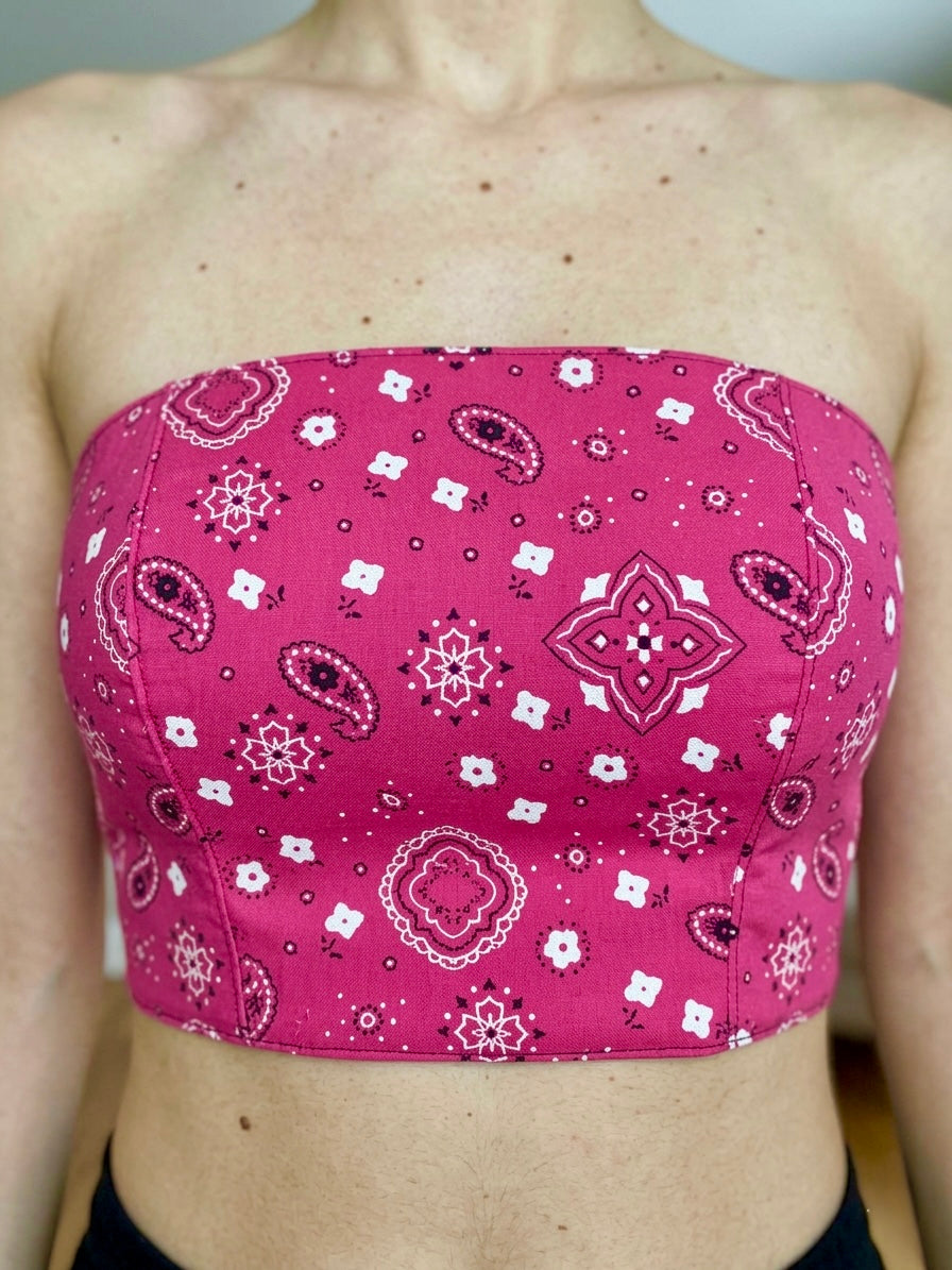 Pink bandeau Bustier Crop top with white patterns on a woman against a neutral background